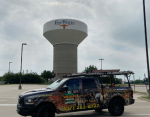 Wildlife Removal truck parked in front of Fort Worth water tower